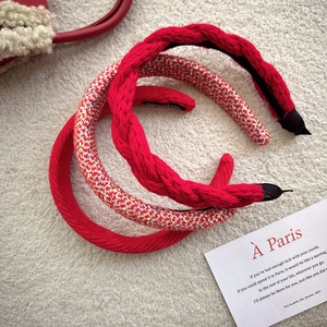 Three red festive headbands featuring knitted, tweed, and twill textures for women