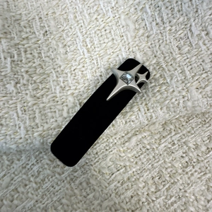 Detailed macro view of black velvet hair clip with silver star rhinestone on tweed fabric