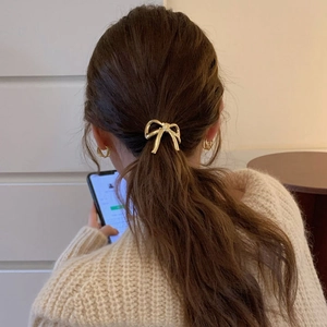 Élastique à cheveux doré avec nœud métallique sur queue de cheval, accessoire élégant femme