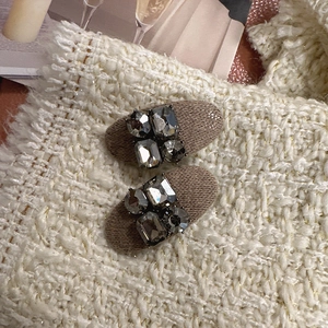 Barrettes à cheveux ovales en tricot kaki avec strass gris sur fond de tweed élégant
