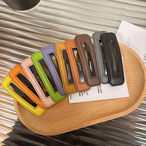 Colorful PU leather rectangular BB clips arranged on a wooden tray with stitch detailing