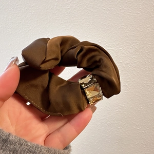 Detail of coffee brown satin scrunchie with sparkling rectangle crystal accents