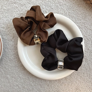 Detail of satin scrunchies set with sparkling crystal buckles in brown and black