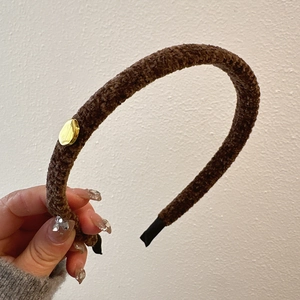 Brown plush headband with golden metal detail and a vintage minimalist design