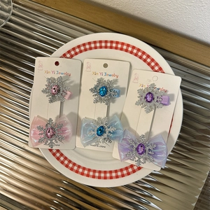 Dettaglio di fermagli per capelli con fiocchi di neve e paillettes in colori pastello