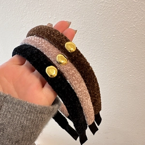 Detailed view of plush velvet headbands with vintage gold metal accents in three colors