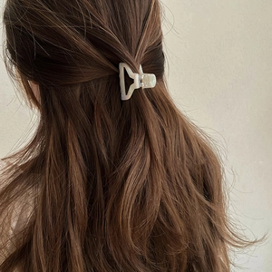 Pearlescent white acetate hair claw clip shown on brunette hair for elegant half-up style