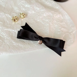 Elegant black ribbon bow hair clip with a round metallic buckle on a white background