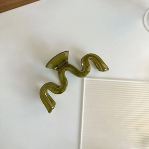 Détail de la grande pince à cheveux vague en résine vert olive au fini translucide