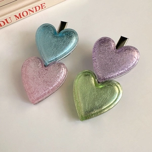 Détail de barrettes en forme de cœurs superposés aux couleurs douces et texture nacrée