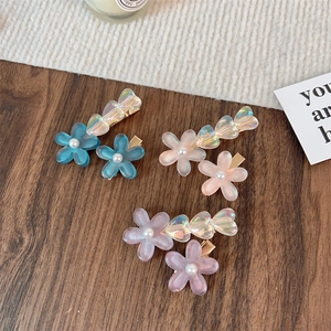 Detailansicht von Blumen- und Herz-Haarspangen in Blau, Rosa und Lila mit Perlen
