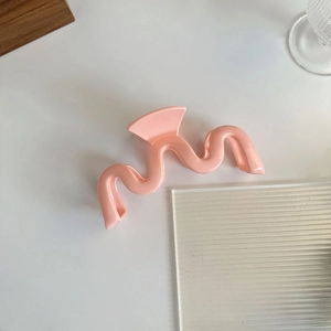Vue détaillée de la pince à cheveux ondulée élégante en finition rose crème lisse