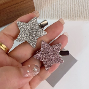 Détail macro de barrettes étoile Y2K avec strass argentés et roses sur base métallique