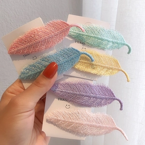Detail view of colorful leaf hair clips with delicate fabric embroidery texture and six pastel tones