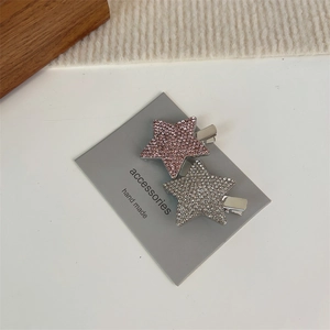 Détail des barrettes en forme d'étoile avec strass roses et argentés sur carte