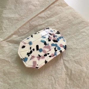 Macro view of octagon acetate hair clip with blue and purple terrazzo pattern on paper