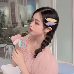 Detailed view of leaf shaped macaron color embroidery hair clip on a model side hair