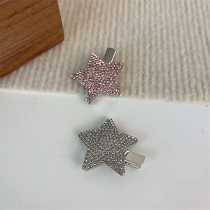 Vue détaillée de deux barrettes en forme d'étoile avec des strass roses et argentés