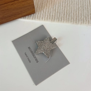 Gros plan sur la pince à cheveux étoile argentée Y2K avec strass sur carte d'accessoires