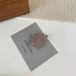 Détail d'une barrette étoile Y2K avec strass roses sur une base en métal argenté brillant