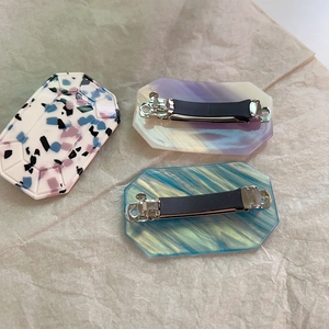 Detailed view of octagon acetate hair clips with marble patterns and metal spring clips
