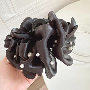 Détail d'une grande pince à cheveux en organza noir avec perles pour coiffures volumineuses