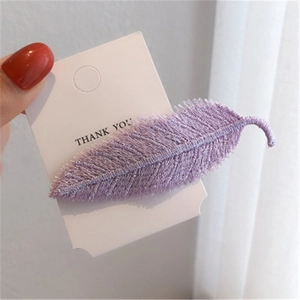 Detail of purple embroidered leaf hair clip showing delicate fabric texture and pattern