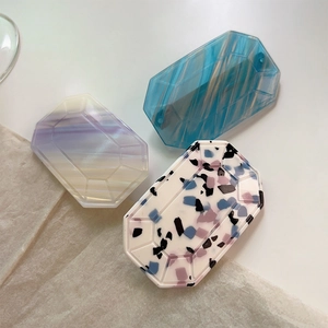 Detail of octagonal resin clips in blue stripe, gradient purple, and terrazzo patterns
