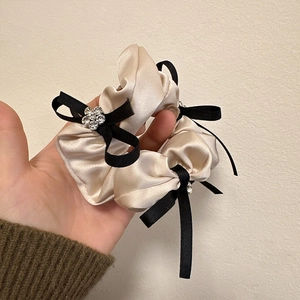 Chouchou élégant en satin champagne avec nœuds noirs et détail de fleur en strass