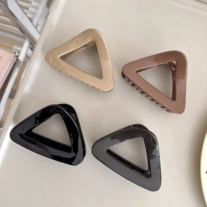 Detailed set of four minimalist geometric triangle hair claws in neutral colors