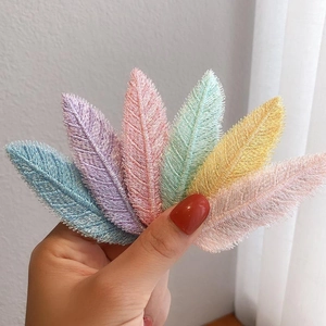 Set of six colorful leaf-shaped embroidered patches in macaron pastel tones held in hand