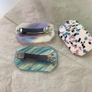 Three geometric acetate spring hair clips with blue marble and starlight patterns