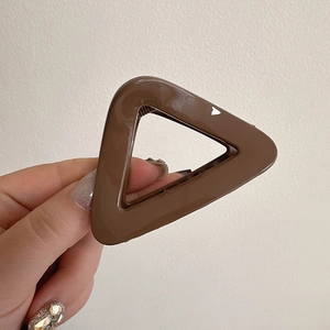 Detail view of coffee brown triangular hair claw clip with glossy geometric finish