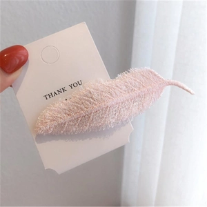 Elegant pink feather-shaped hair clip on a white gift display card for women