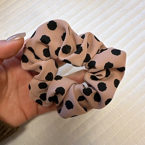Detail shot of the satin dot scrunchie in dusty rose with smooth textured fabric