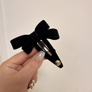 Elegant black velvet bow hair clip with gold bead detail for women's hair styling