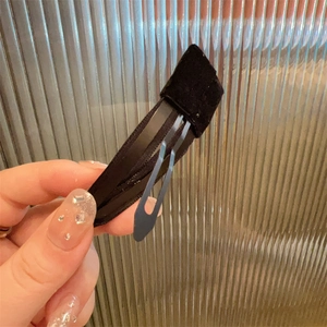 Detailed view of a vintage black velvet hair clip with premium textured finish