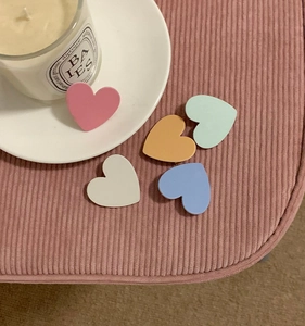 Close-up of matte heart-shaped hair clips in pink, blue, orange, white and purple