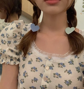 Detail of candy-colored heart hair clips on braided hair with a floral outfit