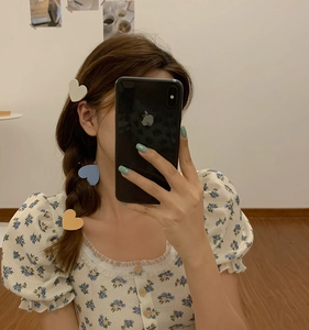 Three matte candy-colored heart hair clips in cream, blue, and yellow on model's hair