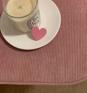 Detailed view of a matte pink heart hair clip on a white ceramic plate and fabric