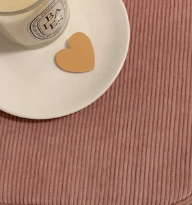 Close-up of heart-shaped hair clip with soft peach matte finish on a white ceramic tray