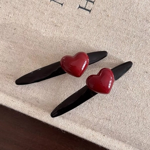 Minimalist red heart hair clips with glossy resin finish on dark duckbill base
