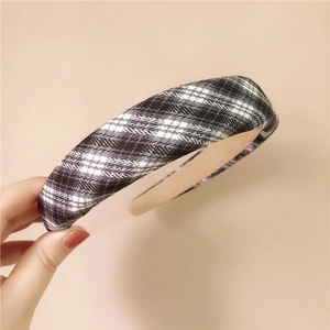 Close-up of a padded plaid headband featuring black and white grid fabric texture