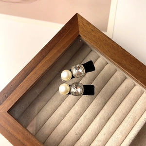 Détail de barrettes en velours avec perles d'imitation et un grand cristal carré