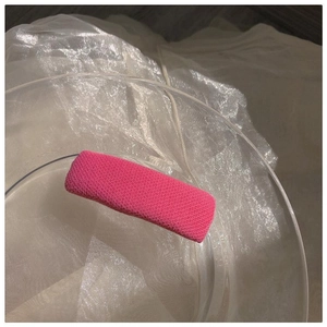 Nahaufnahme der rosafarbenen gestrickten Haarklammer auf einem Glastellerrand