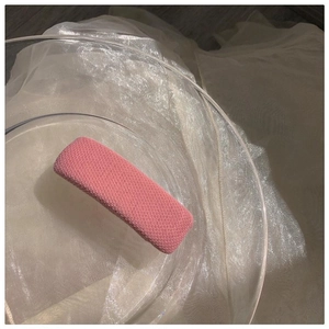 Detaillierte Makroansicht einer rosa gestrickten Haarklammer mit Wabenstruktur