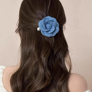 Vintage blue denim rose hair clip with pearl accent on brown wavy hair for women