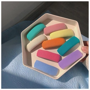 Set mit 9 bunten Schwamm-Haarspangen in Macaron-Farben auf weißem Tablett