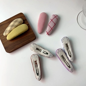 Close-up of pastel plaid and solid color fabric hair clips with silver metal backing